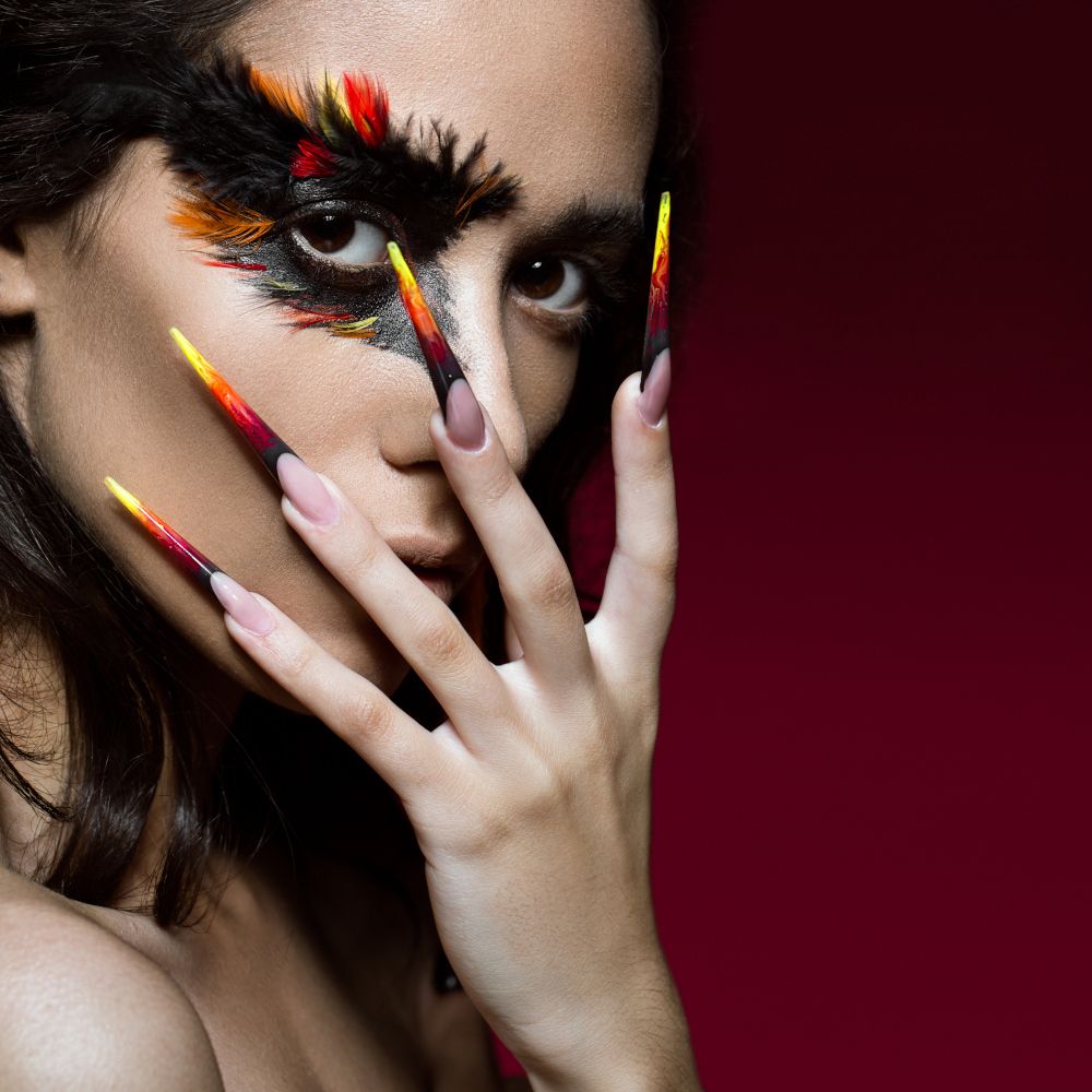Chica con uñas acrílicas y maquillaje creativo.