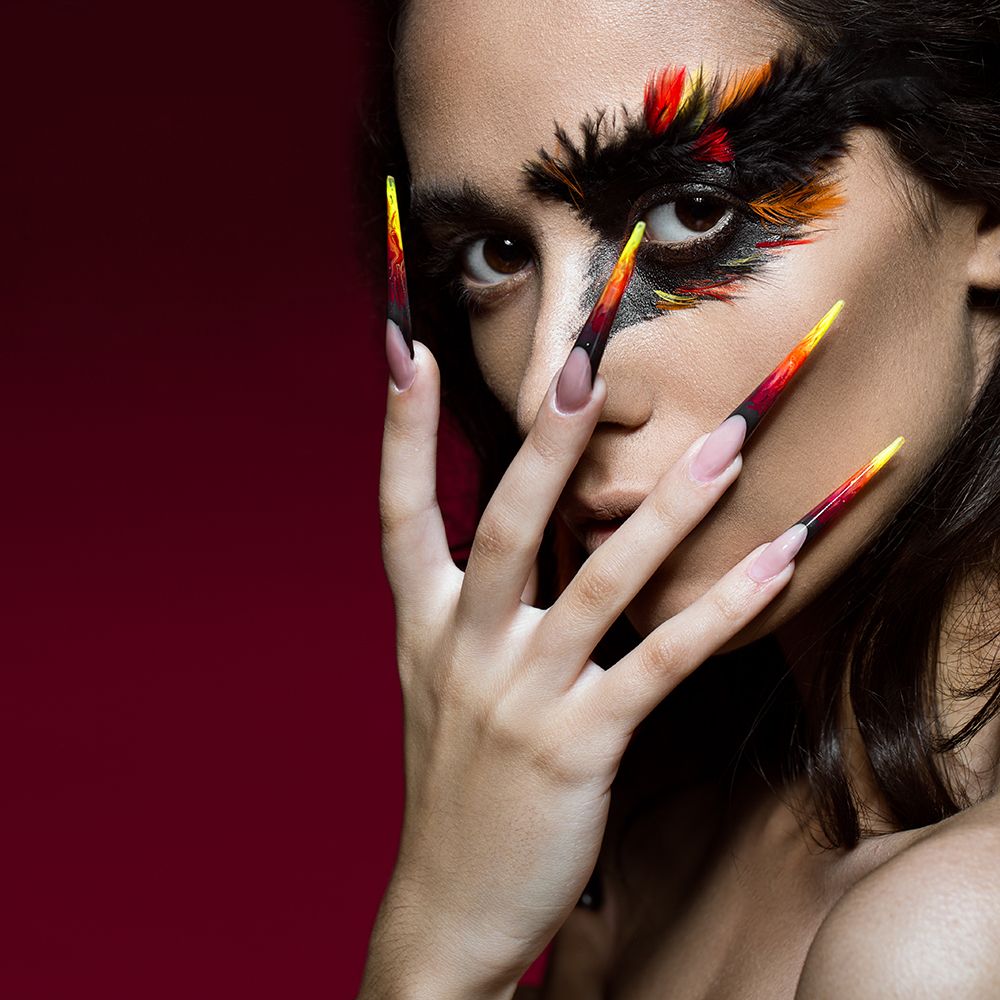 Chica con uñas acrílicas y maquillaje creativo.